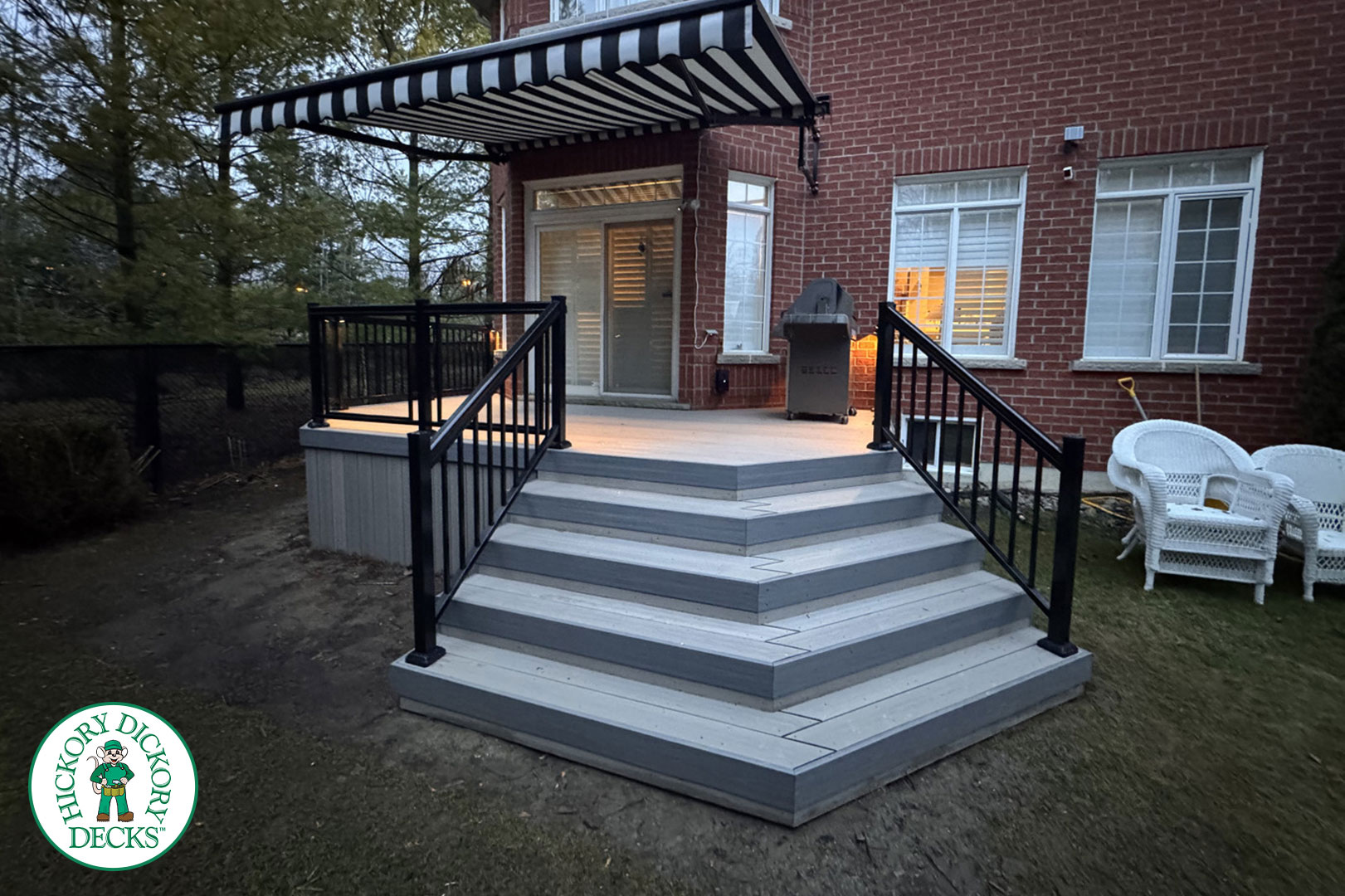 Backyard deck with striped awning.